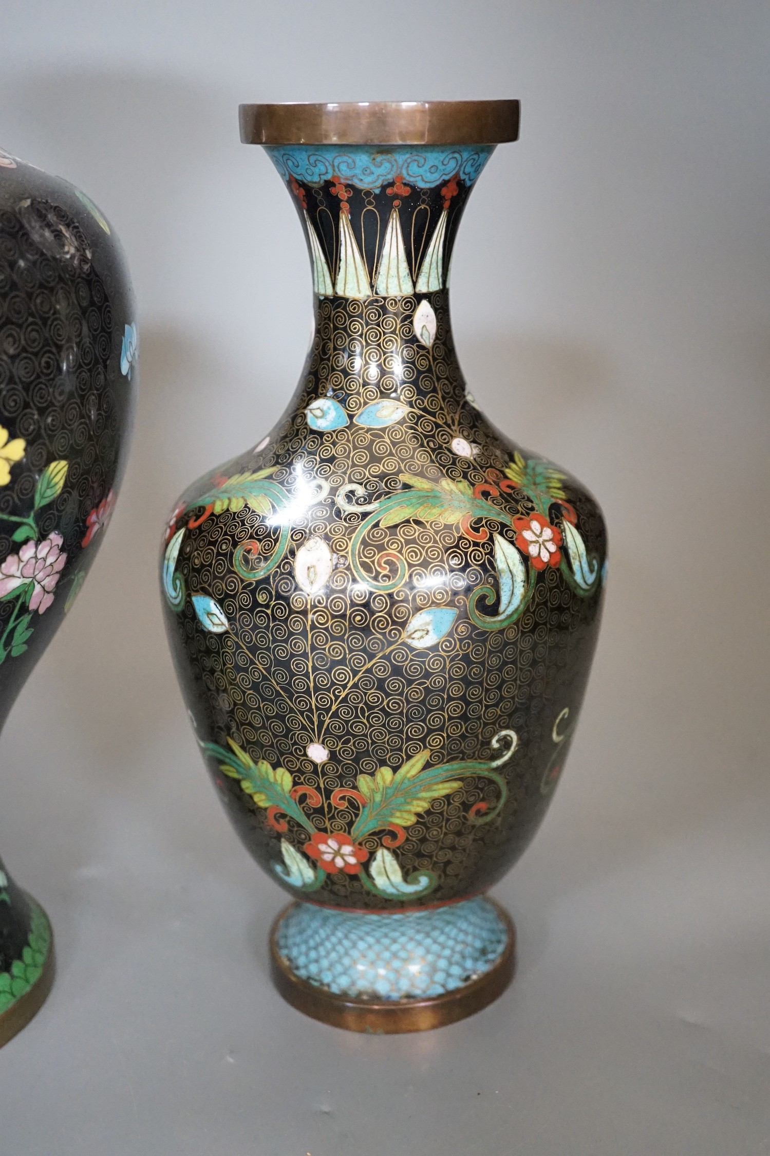 Two Chinese cloisonné enamel vases, and a porcelain ‘lion dog’ vase, tallest 33cm